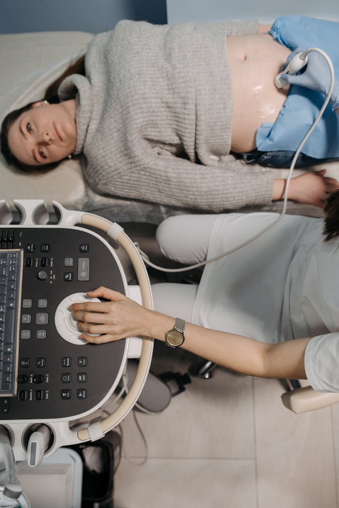 Doctor performing an ultrasound checkup on a female patient in a clinic.